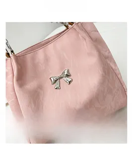 Close-up of pink velvet tote bag featuring a silver metal butterfly ornament and texture