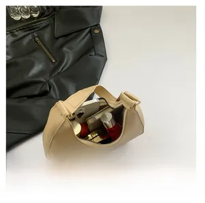 Intérieur spacieux du sac hobo beige montrant téléphone, rouge à lèvres et objets
