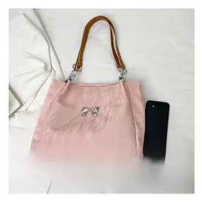 Pink tote bag detail with metallic butterfly ornament and chain strap size comparison