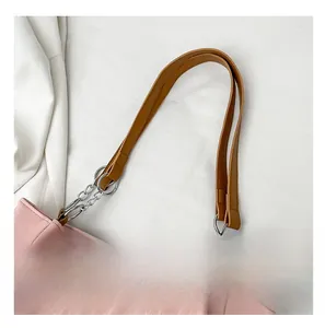 Detail of pink pleated shoulder bag with brown leather strap and silver metal chain