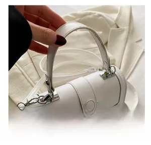 Detail shot of white crossbody bag with black stitching and silver-tone hardware accents