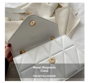Detail of white quilted handbag featuring a secure gold magnetic hardware closure