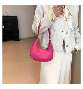 Détail du sac selle croissant rose montrant le cuir texturé et les finitions dorées