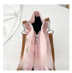 Detail of pink embossed tote bag with smooth silver zipper and brown leather strap