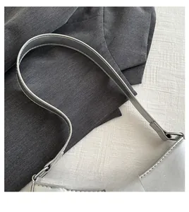 Detail showing the comfortable handle and fine stitching of the silver shoulder bag