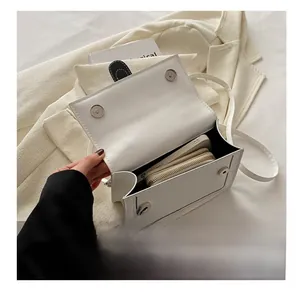Interior capacity of the white leather square bag showing phone and wallet storage