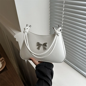 White crescent underarm bag with silver bow accent and knotted rope handle design