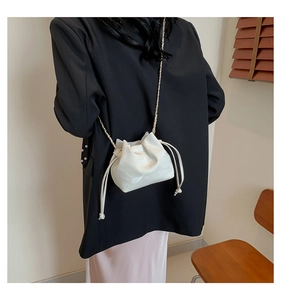 Detailed macro view of white marble texture soft leather bucket bag with gold chain