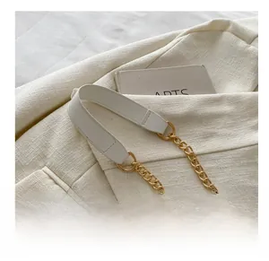 Detail of white leather and gold metal chain strap showing high-quality stitching and craftsmanship