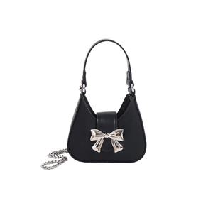 Black leather handbag with silver metal bow accent and chain strap on white background