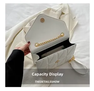 Close-up of white quilted crossbody bag capacity showing space for a smartphone