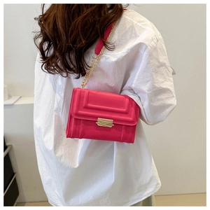 Detailansicht der pinkfarbenen Umhängetasche mit Reliefmuster und goldener Kette