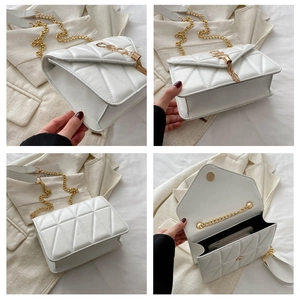Detail view of white quilted crossbody bag with gold chain strap and tassel charm