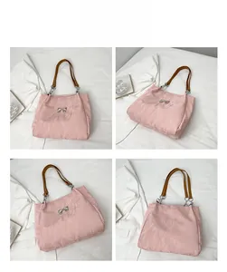 Detail view of pink pleated velvet tote bag featuring a silver butterfly bow ornament