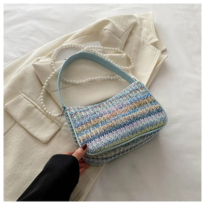 Detail of bohemian woven bag with colorful embroidery butterfly and pearl chain strap