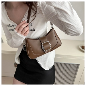 Detail of vintage brown leather underarm bag featuring a large silver buckle closure
