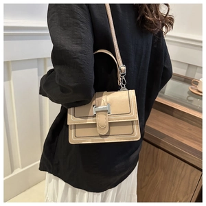 Detail of khaki crossbody bag featuring contrast stitching and brushed metal buckle