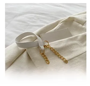 Close-up of cream textured leather and gold chain shoulder strap on a quilted bag