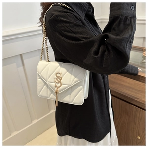 Détail d'un sac bandoulière blanc matelassé avec logo SS doré et bandoulière chaîne