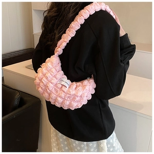 Detailed close-up of pink bubble pleated fabric on a trendy crescent shoulder bag