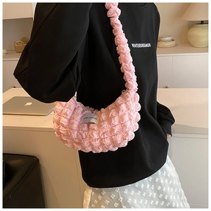 Detailed macro shot of pink bubble textured fabric and Love Fashion label on the shoulder bag