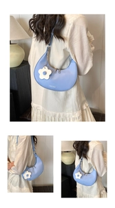 Close-up of light blue hobo bag with a 3D floral charm and adjustable shoulder strap