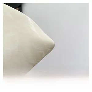 Macro shot of marble-patterned off-white leather fabric with premium stitching details