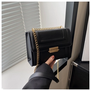 Close-up of black matte PU leather crossbody bag with gold chain and metal buckle