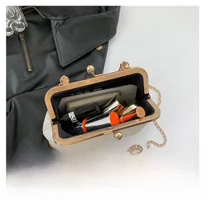 Detail view of the beige crossbody bag interior with retro gold metal clasp closure