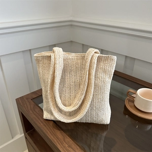 Borsa tote minimalista in paglia intrecciata beige con manici lunghi per l'estate