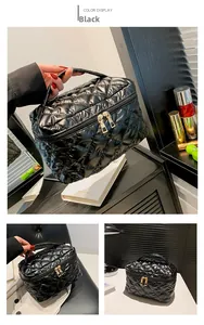 Dettaglio del beauty case trapuntato nero in nylon lucido con cerniere dorate