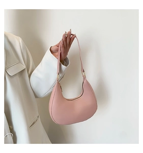 Détail du sac à bandoulière croissant rose pâle avec fermeture éclair dorée et cuir mat