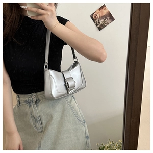 Silver metallic shoulder bag with belt buckle detail shown in a mirror selfie outfit