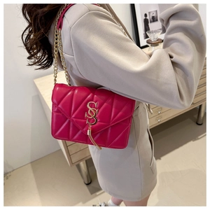 Detail of quilted fuchsia shoulder bag with gold chain strap and elegant tassel