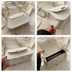 Detail of cream baguette bag showing golden bar hardware and interior phone storage