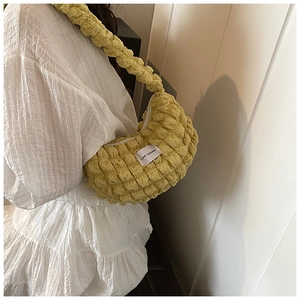 Detail of lime green popcorn texture underarm bag featuring a LOVE FASHION label