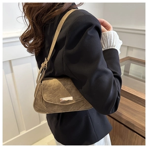 Detail of vintage olive green matte shoulder bag with metallic rectangular buckle on model