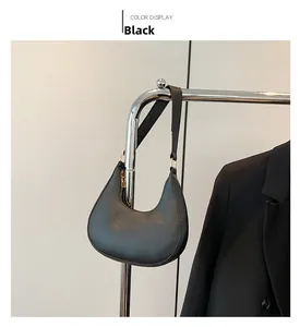 Détail du sac hobo noir minimaliste avec cuir texturé et bandoulière réglable