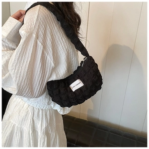 Detail of black quilted bubble texture shoulder bag with LOVE FASHION woven label