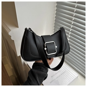 Detail shot of black baguette bag featuring a large silver square metal buckle and smooth leather