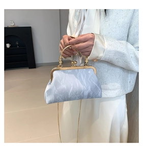Detail of light blue marble textured evening bag with gold metal clasp and handle