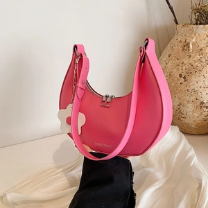 Elegant rose pink crescent shoulder bag with white daisy charm and sleek silver zipper