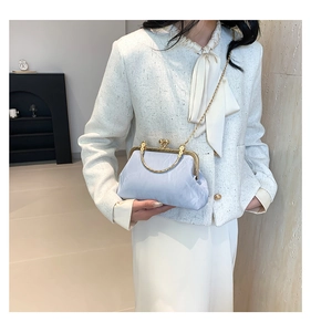 Detail of light blue pleated cloud clutch with gold chain strap and metal handle