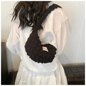 Detail of black bubble textured crescent bag with Love Fashion label on shoulder