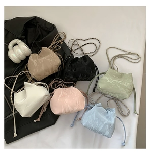 Detailed display of vintage drawstring bucket bags in six colors with chain straps