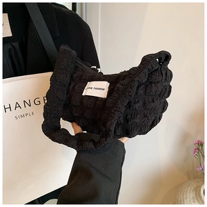 Detail of black bubble textured shoulder bag with LOVE FASHION woven label detail