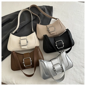Flat lay of multiple minimalist leather baguette bags in neutral colors with metal buckles