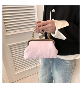 Close-up of pink pleated fabric bag featuring a gold metal handle and delicate chain strap