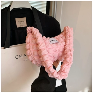 Detail of pink pleated bubble texture fabric and woven label on a stylish hobo bag
