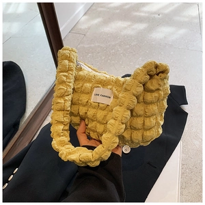 Detail of yellow bubble texture handbag with LOVE FASHION woven label and zipper closure